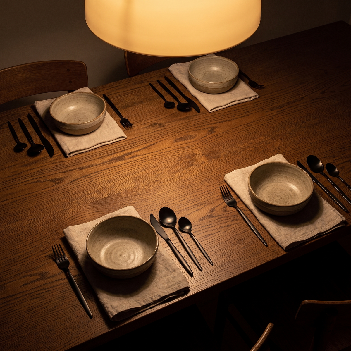 Cutlery on a dark oak table set for four
